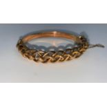 A rose gold bangle formed from interlinking chased links, stamped '9c', 16 gm