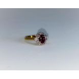 An 18 carat hallmarked gold flowerhead cluster dress ring set central oval ruby surrounded by 10