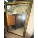 A large rectangular gilt framed rectangular bevelled edge wall mirror