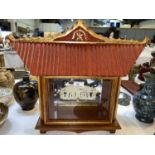 A Chinese pale jade coloured carved stone inside a shrine style display cabinet with glazed