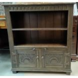 A carved oak reproduction bookcase, 2 height with cabinet under