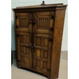 Reproduction Jacobean style oak floor standing cupboard enclosed by 2 pairs of panelled doors