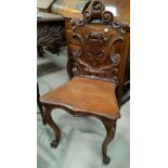 A Victorian carved mahogany hall chair with shield back; an Edwardian carved mahogany bedroom chair;