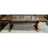 A rustic oak refectory table with distressed plank top and shaped ends on stretcher and peg base,