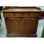 A Victorian mahogany small side cabinet with raised gallery and 3 drawers over double arched panel