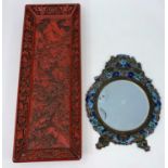 A cloisonne framed Chinese mirror decorated with sea horses etc and a cinnabar coloured tray