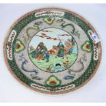 A late 19th / early 20th century Kangxi style shallow dish decorated in polychrome with central