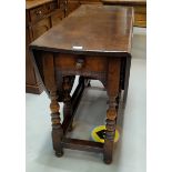 An 18th century style oak drop leaf dining table on turned balluster legs in the manner of