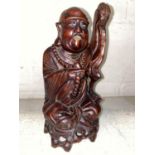 A Chinese carved hardwood seated figure with beads and whisk height 27 cm