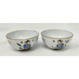 A pair of Chinese tea bowls both depicting a warrior archer figure to one side and Chinese