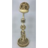 A large 19th century carved ivory puzzle ball on stand with base of carved dragons, the pillar with