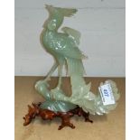 A Chinese jade carving of a bird of paradise, on hardwood disc stand, height 19 cm