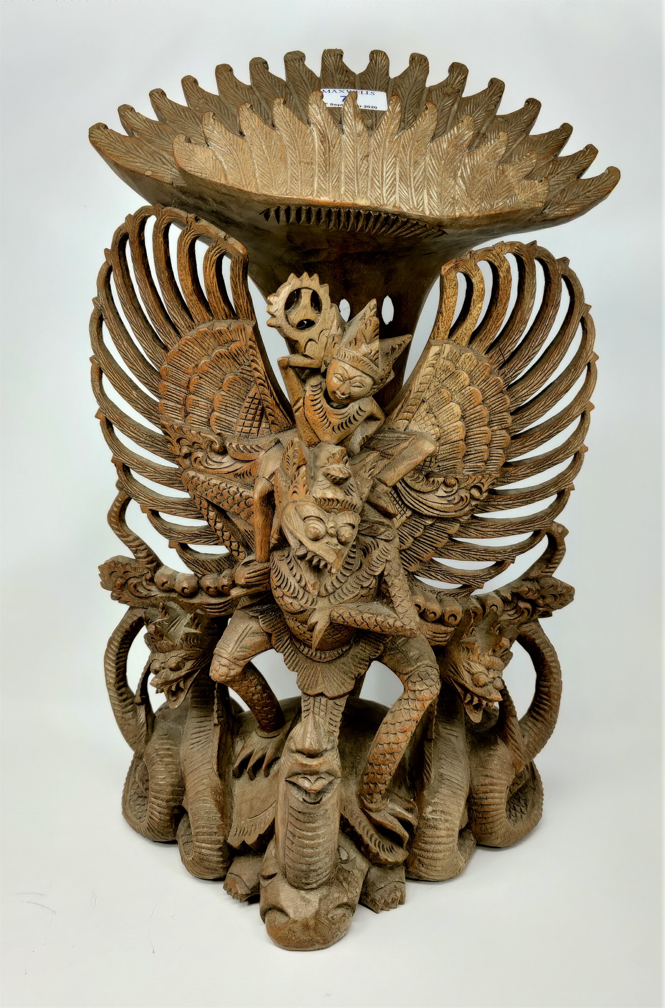 An Indonesian large carved group: winged figure on tortoise, height 51 cm