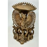 An Indonesian large carved group: winged figure on tortoise, height 51 cm