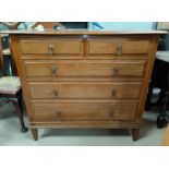 A 1920's chest of four long two short drawers with drop handles and tapering legs