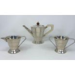An Art Deco three piece silver tea service comprising tea pot, mil and sugar with tapering bodies