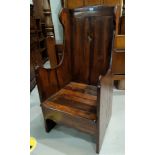 A distressed oak lambing chair in the Georgian style