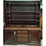 An 18th Century oak dresser with reverse breakfront, the later high raised back with moulded