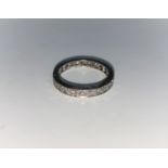 A white metal diamond set eternity ring, unmarked, tests as 18 ct, 3.8 gm