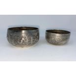 Two Middle Eastern white metal bowls decorated in relief with elephants, snakes etc