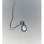 A 14 carat gold pendant set with pale blue stone