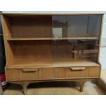 A mid 20th century teak sliding door bookcase with two drawers bellow
