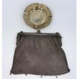 A circular silver ashtray, London 1912; a silver plated mesh evening bag