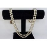 A cultured pearl double strand necklace, with 9 carat clasp set pearl and ruby