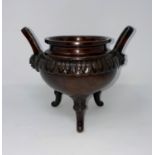 A 19th century Chinese bronze incense burner, cauldron shaped with facemask side handles and 3