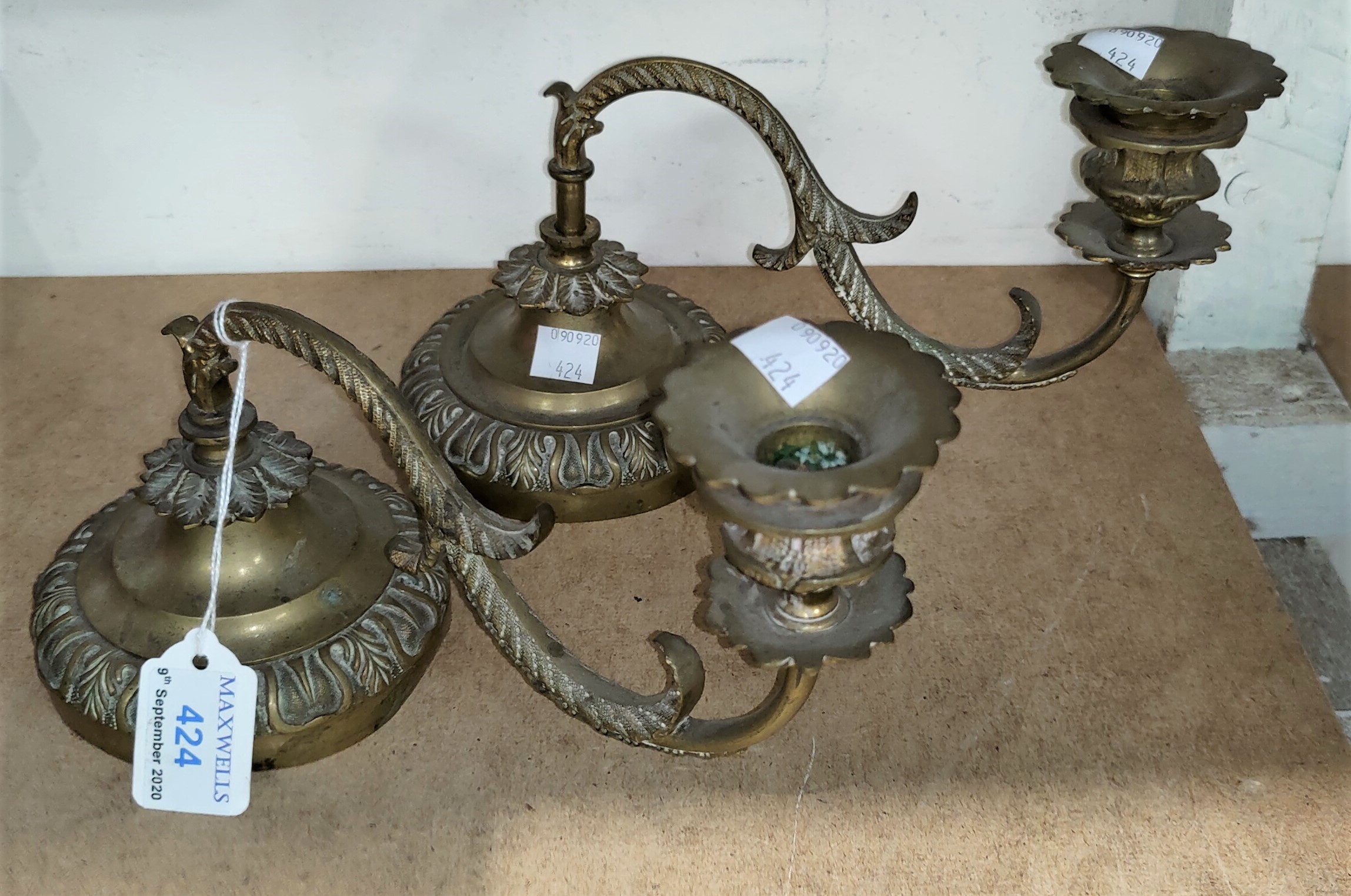An early 19th century pair of brass ornamental candle sconces for a grand piano, with weighted bases
