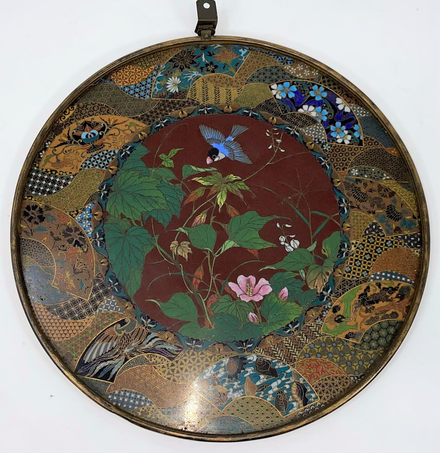 A late 19th/early 20th century Japanese cloisonné circular wall plaque, the central panel with