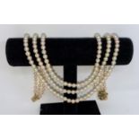 A cultured pearl necklace, triple strand with yellow metal circular flower head clasp set 6