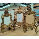 A pair of gilt metal picture frames in the classical manor and a single gilt metal picture frame de