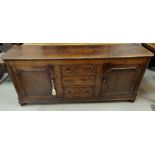 An 18th Century countrymade oak dresser base with 2 panelled end cupboards and 3 central drawers