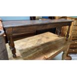 An oak bench on turned legs; a terra cotta umbrella stand