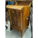 An Edwardian fall front coal box in carved pollard oak