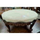 A Victorian carved walnut oval footstool