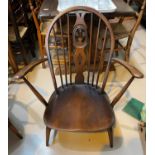 A pair of Ercol dark wood hoop and stick back armchairs; a similar lightwood chair