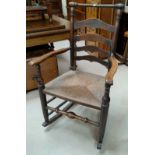 A 19th century Macclesfield school ladder back elm rocking armchair with rush seat