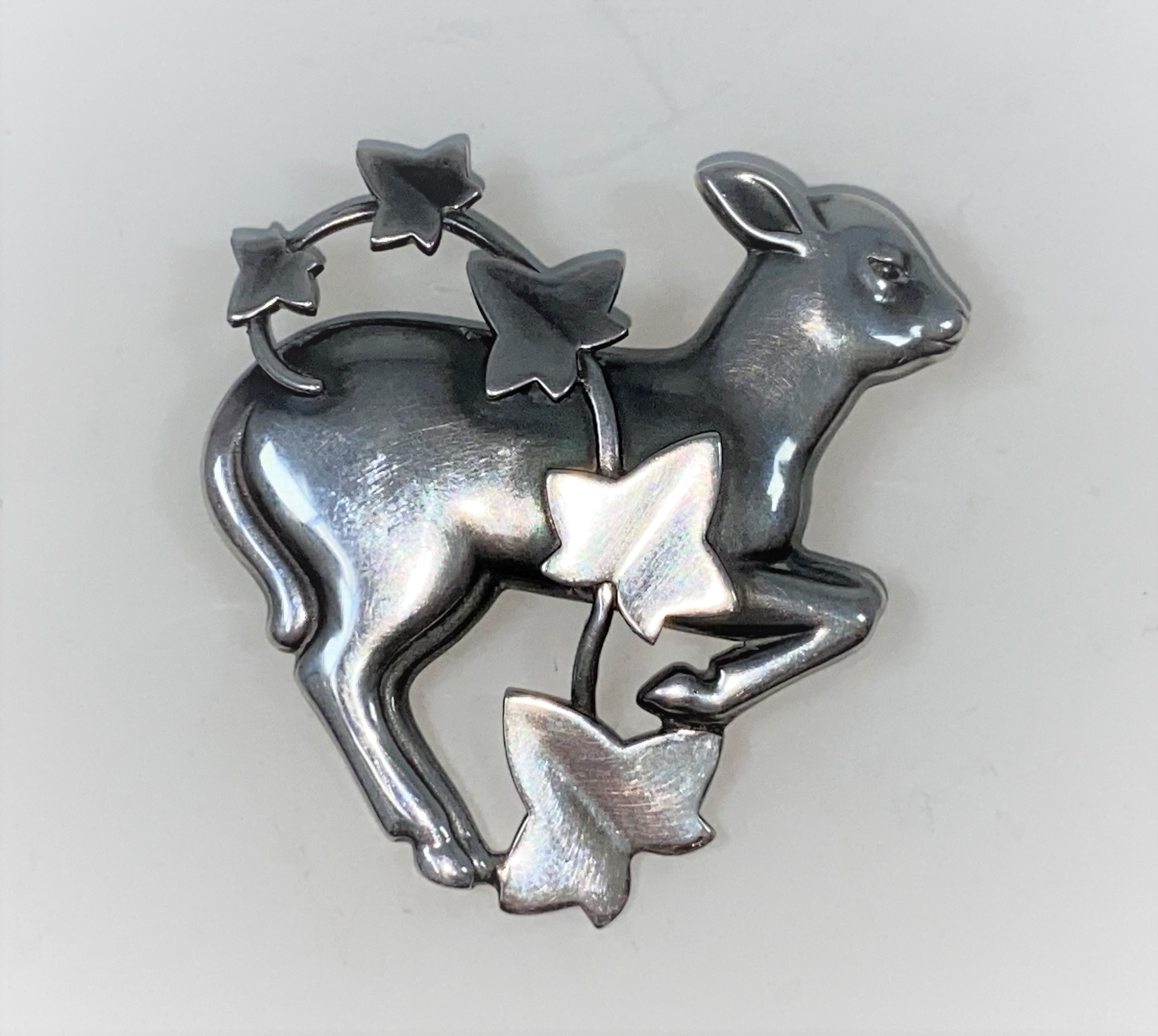 Georg Jensen: a silver brooch designed by Arno Malinowski, gambolling lamb with ivy overlay, stamped