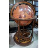 A mid 20th century reproduction terrestrial globe drinks trolley with hinged lid and castors