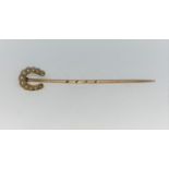 A yellow metal seed pearl set, horseshoe pin. Stamped 15ct (1.5g)