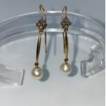 An early 20th Century pair of drop earrings each set 4 small diamonds and a pearl with bar
