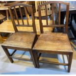 A pair of Georgian country made elm rail back dining chairs with solid seats and square legs