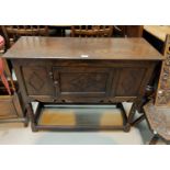 An oak Jacobean style single panel door side cabinet with carved decoration, ridged legs etc.