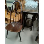 A 1930's oak drop leaf dining table with oval top; 4 Ercol hoop and stick back chairs