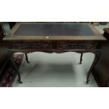 An Edwardian mahogany writing table with inset leather effect top and 2 frieze drawers, on