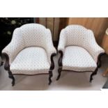A pair of Edwardian carved mahogany tub shaped armchairs, reupholstered in floral print Damask, on