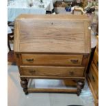 a 1930's oak two drawer bureau on bulbous legs.