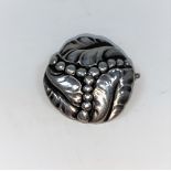 Georg Jensen: a silver brooch with embossed leaves and balls, hollow (worn), pull pin clasp, stamped